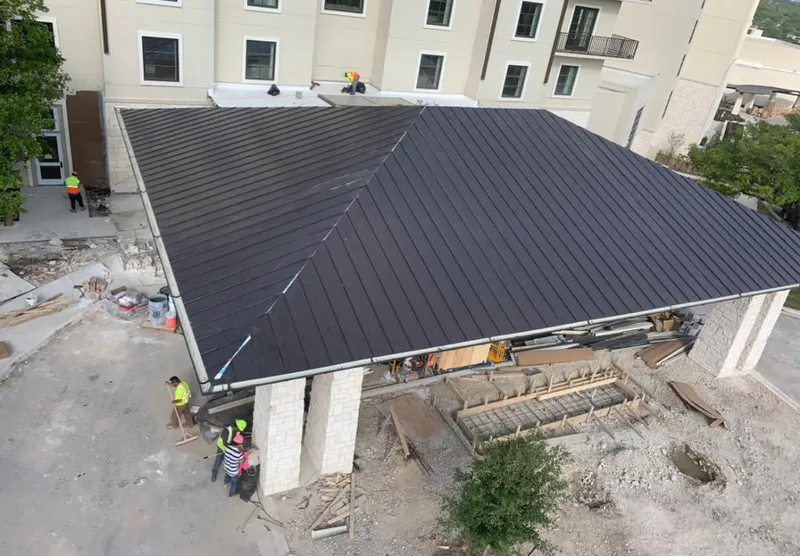 Metal roofing installation team working on a commercial building in Henderson